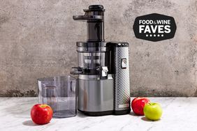 Hurom H101 Slow Juicer displayed with apples on marble counter