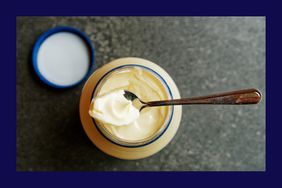 A jar of mayonnaise with a spoon on top.