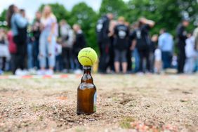 26 May 2022, Schleswig-Holstein, Elmshorn: A game ball lies on a beer bottle in the middle of a playing field. After two years of Corona break, the Flunkyball "World Championship" has been held in Elmshorn for the eighth time.