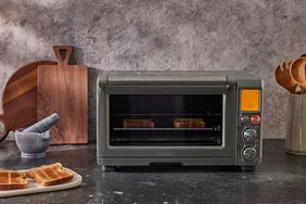 Breville Smart Oven displayed on a black countertop next to kitchen utensils