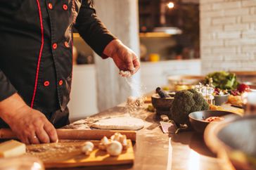 A chef works with fresh dough in the kitchen