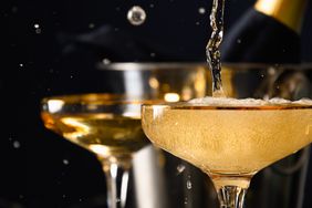 Pouring champagne to gold-rimmed coupes