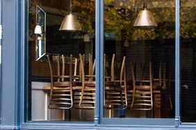 An empty restaurant with chairs stacked on tables