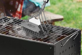 The Grillart Grill Brush and Scraper being used to clean a grill grate