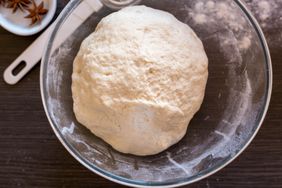 Proofed dough in a glass bowl.