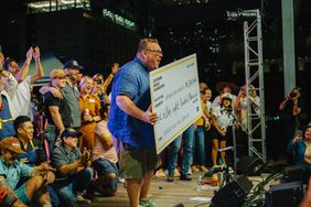 Founding Director Chris Shepherd with the giant check after Southern Smoke Festival 2023. 