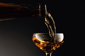 A bottle of Marsala wine pouring into a glass