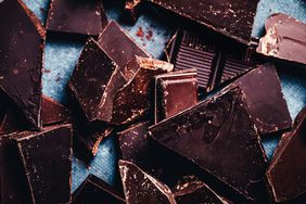 Close-up of pieces of raw chocolates on kitchen counter. Dark chocolate bar pieces.