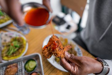 Detail of food being held by hand from Patois, Toronto